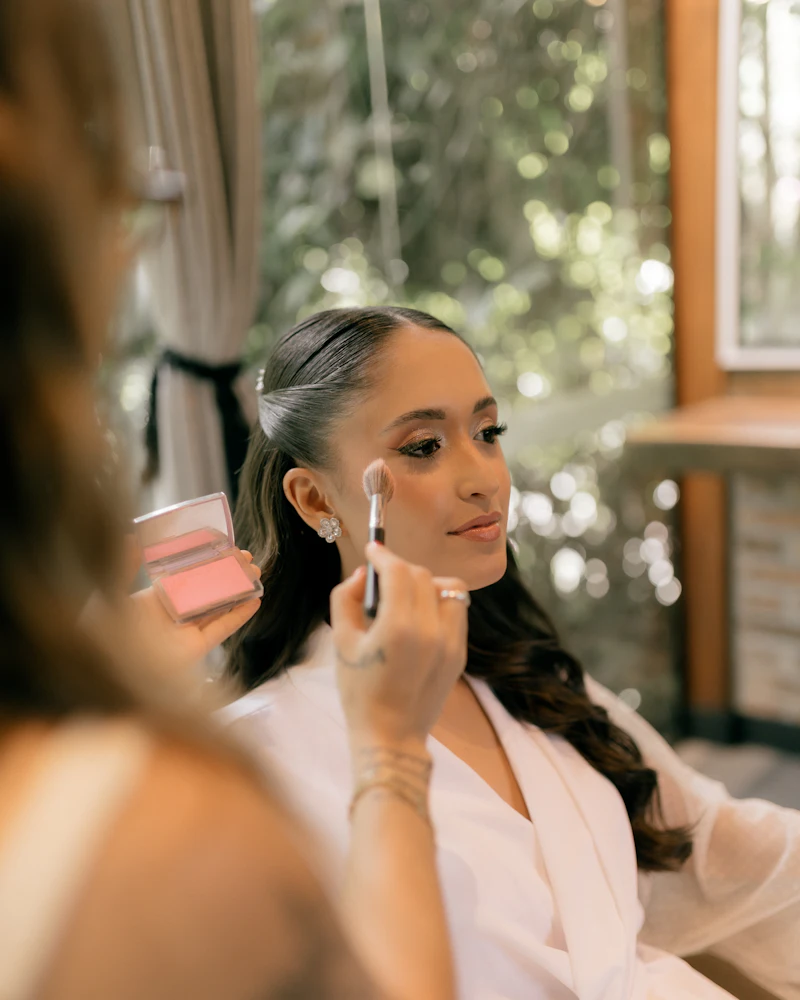 Trainer demonstrating makeup on a model to a small group of Finenticee students