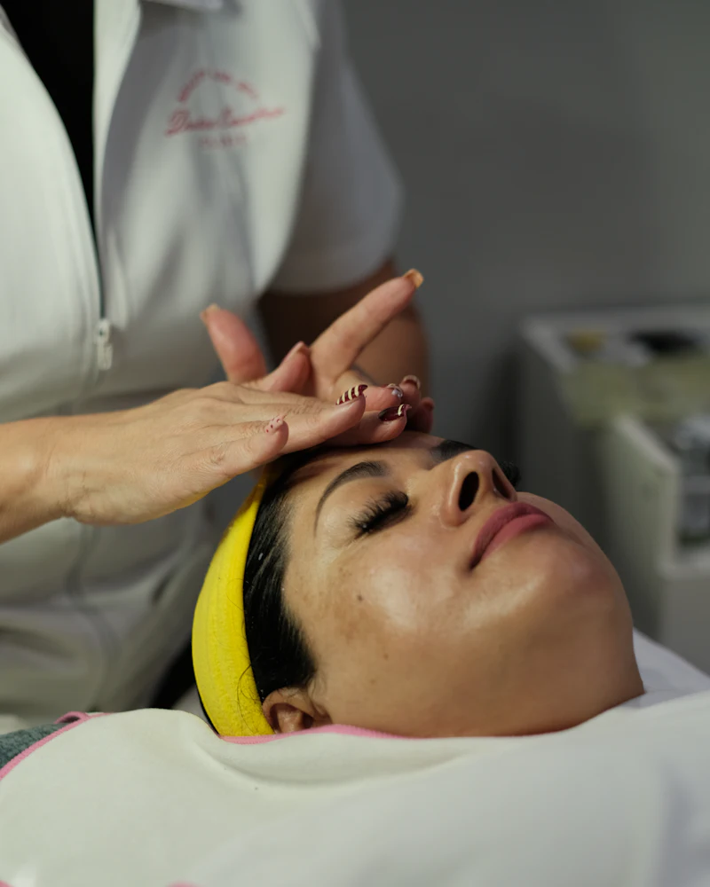 Student practising facial massage strokes on a model at Finenticee academy